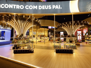 Prateleiras curvas iluminadas para exposição e venda de livros no pavilhão da feira.